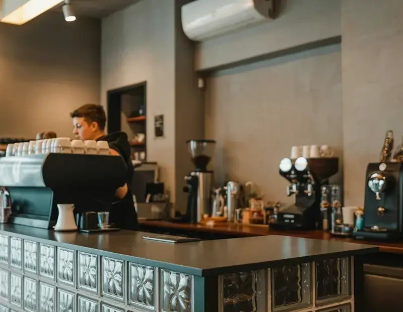 Modern Coffee Shop Counter Ideas with Glass Blocks | Warm Lighting & Concrete Walls